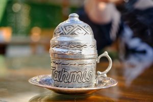 a silver teapot sitting on top of a wooden table